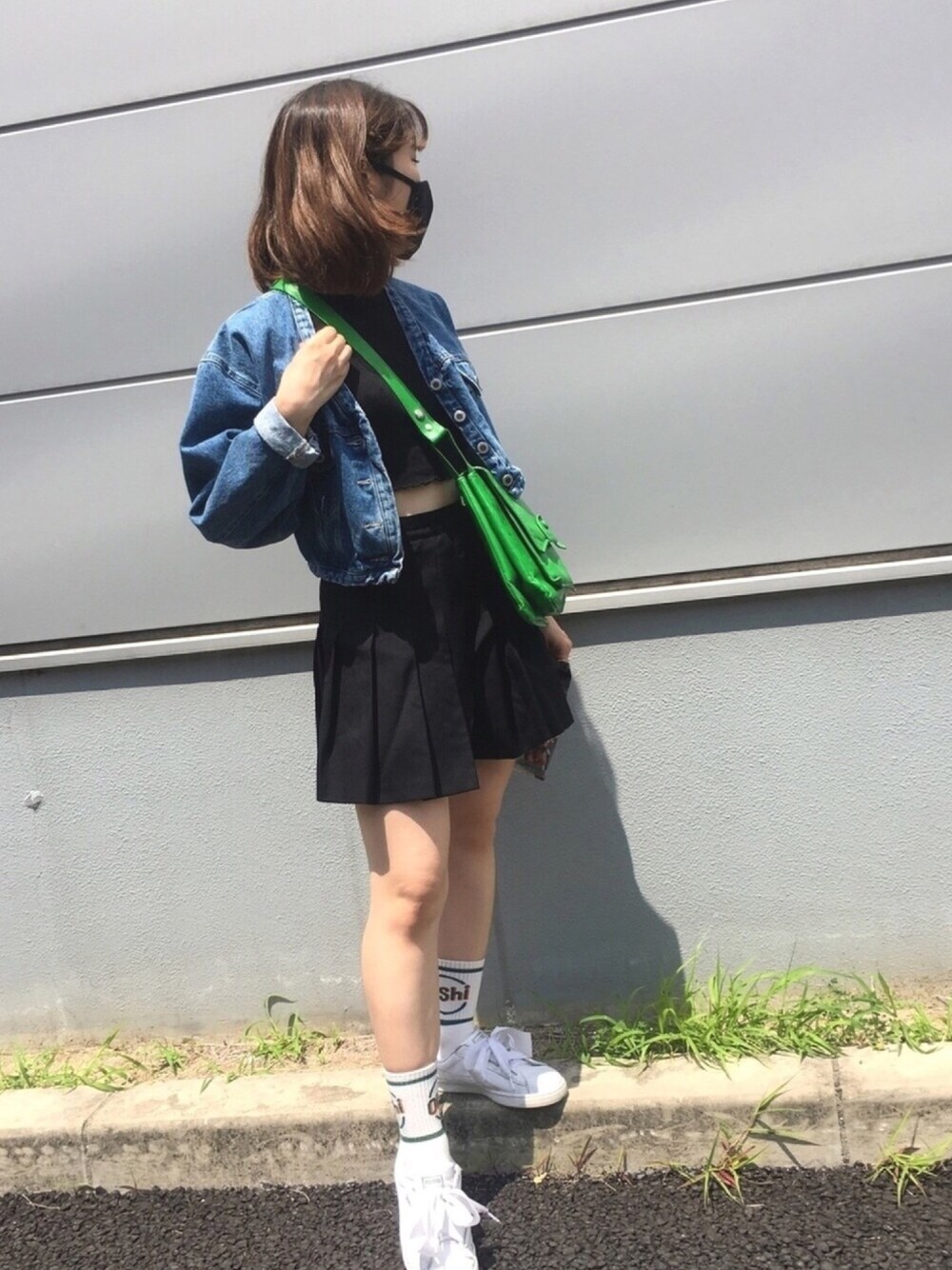 ブラック系のスカート、ブルー系のデニムジャケット、ホワイト系のスニーカーを着用したレディースの夏コーディネートの1枚目の写真