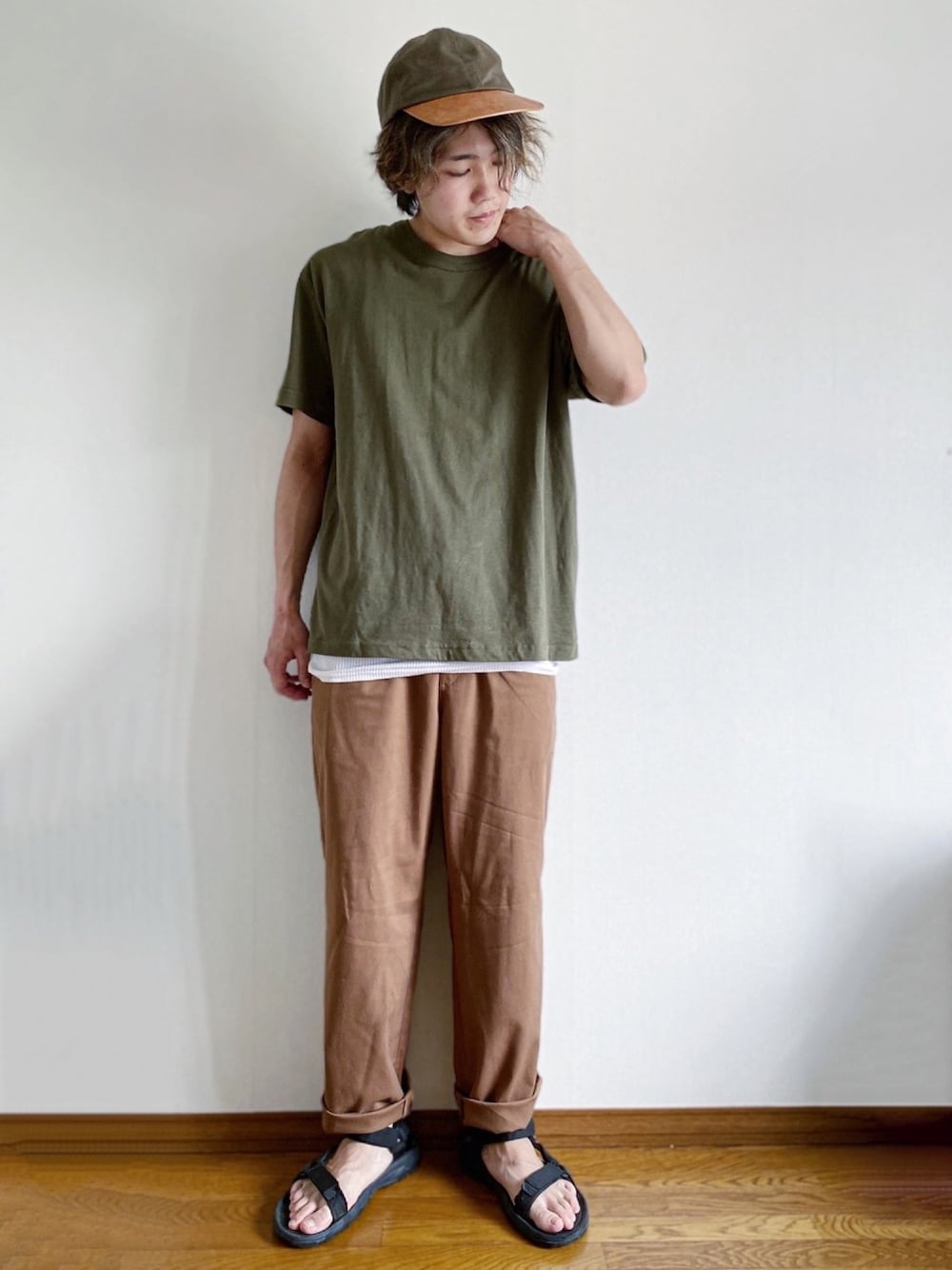 グリーン系のTシャツ/カットソー、ブラウン系のパンツ、ブラック系のサンダルを着用したメンズの春コーディネートの1枚目の写真