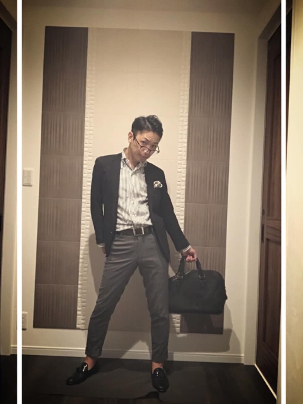 ブラック系のテーラードジャケット、グレー系のスラックス、ブラック系のローファーを着用したメンズの秋コーディネートの1枚目の写真