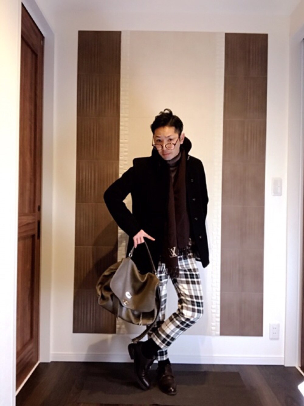 ブラック系のダウンジャケット/コート、ベージュ系のショルダーバッグ、ベージュ系のスラックスを着用したメンズの冬コーディネートの1枚目の写真