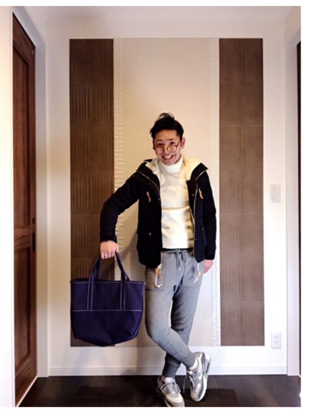 ブルー系のトートバッグ、グレー系のパンツ、グレー系のスニーカーを着用したメンズの冬コーディネートの1枚目の写真