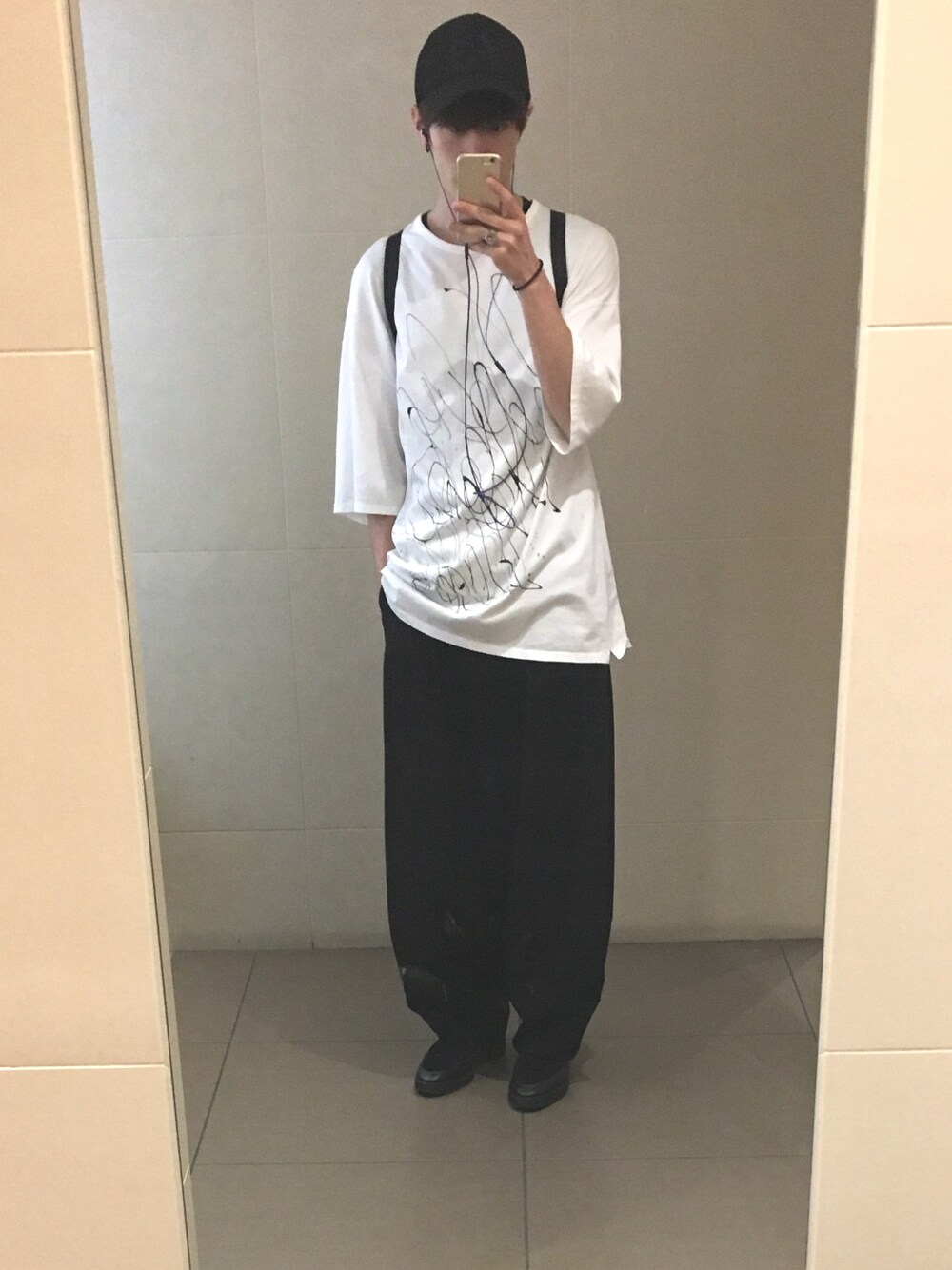 ホワイト系のTシャツ/カットソー、ブラック系のパンツ、ブラック系のスニーカーを着用したメンズの春コーディネートの1枚目の写真