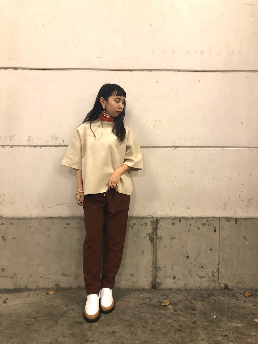 ベージュ系のトップス、ブラウン系のパンツ、ホワイト系のスリッポンを着用したレディースの冬コーディネートの1枚目の写真