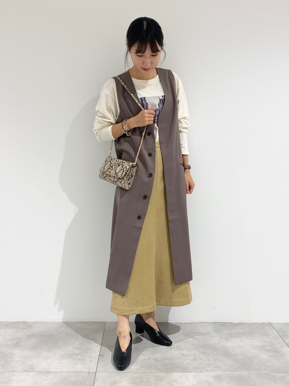 ブラウン系のノーカラーコート、ホワイト系のTシャツ/カットソー、その他のショルダーバッグを着用したレディースの夏コーディネートの1枚目の写真