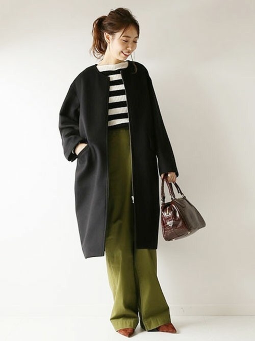 ブラック系のその他アウター、ホワイト系のTシャツ/カットソー、ブラウン系のボストンバッグを着用したレディースの秋コーディネートの1枚目の写真