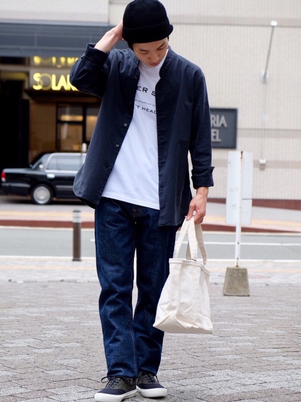 ホワイト系のTシャツ/カットソー、ブルー系のデニムパンツ、ホワイト系のトートバッグを着用したメンズの夏コーディネートの1枚目の写真