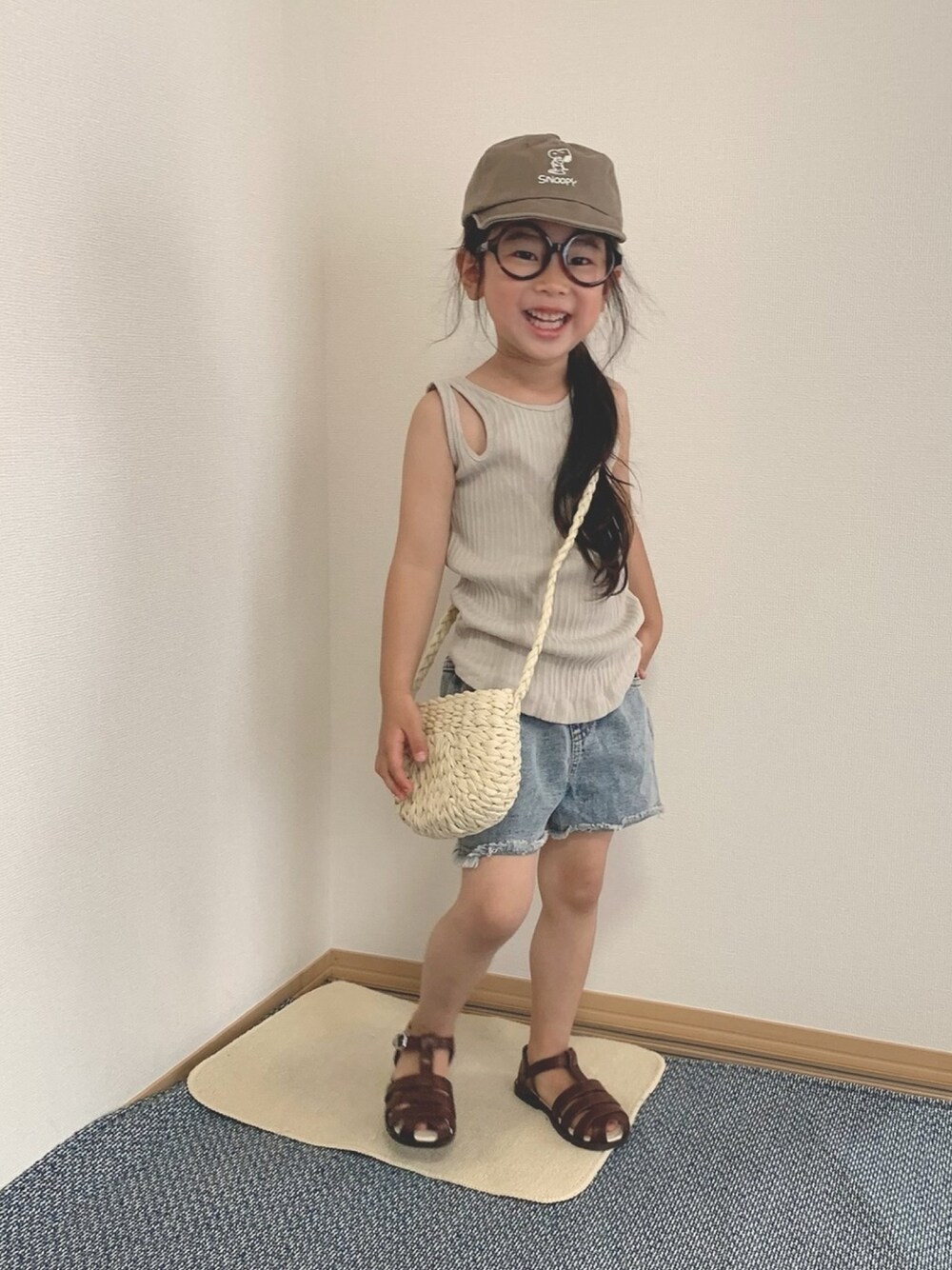 ブラウン系のサンダル、ベージュ系のタンクトップ、ブルー系のデニムパンツを着用したキッズの夏コーディネートの1枚目の写真