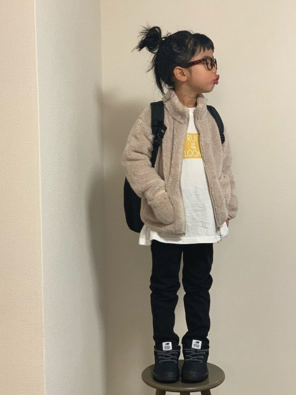 ブラック系のスニーカー、ホワイト系のTシャツ/カットソー、ブラック系のバックパック/リュックを着用したキッズの冬コーディネートの1枚目の写真