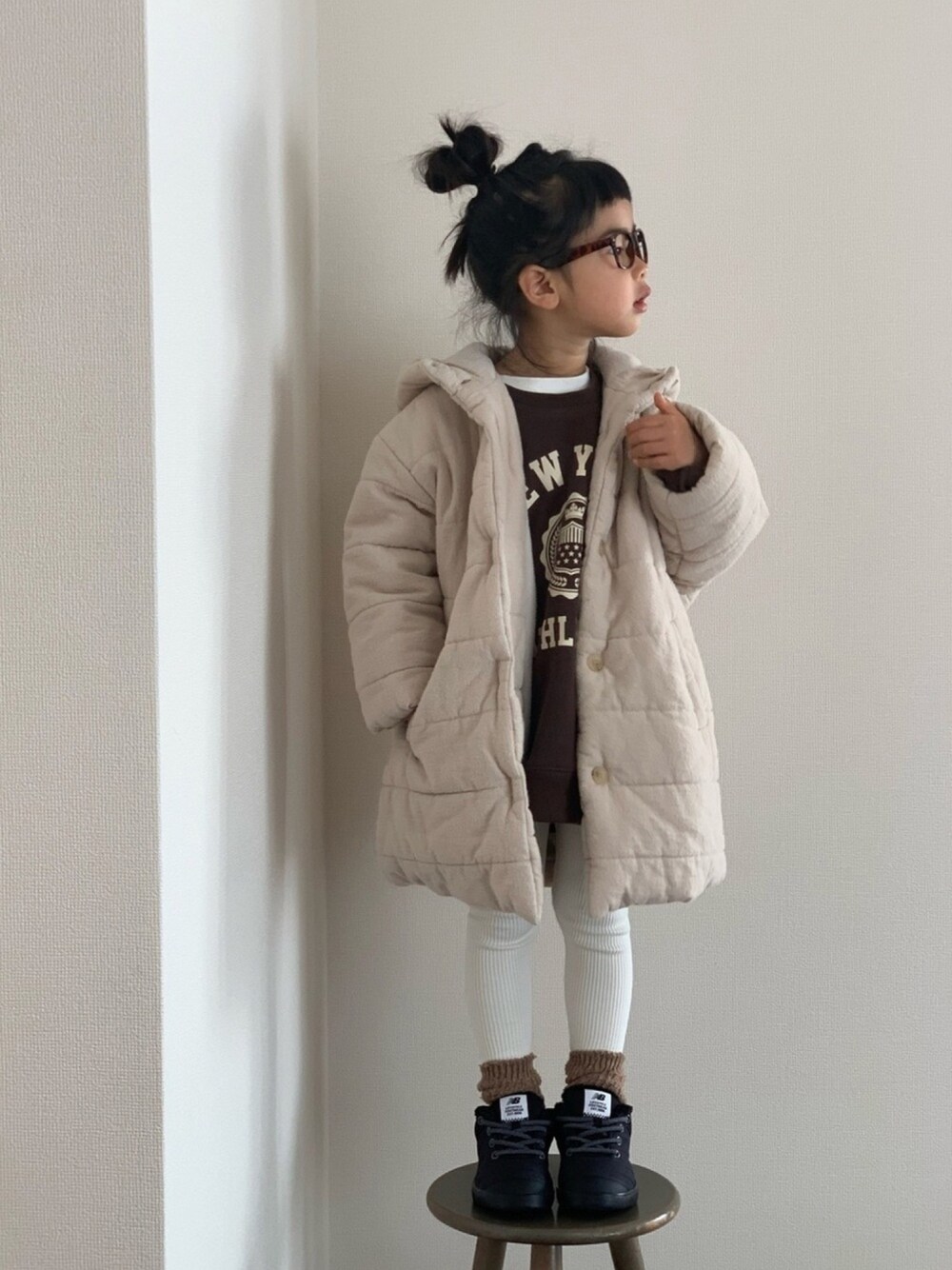 ホワイト系のジャケット/アウター、ブラウン系のスウェット、ブラック系のスニーカーを着用したキッズの冬コーディネートの1枚目の写真