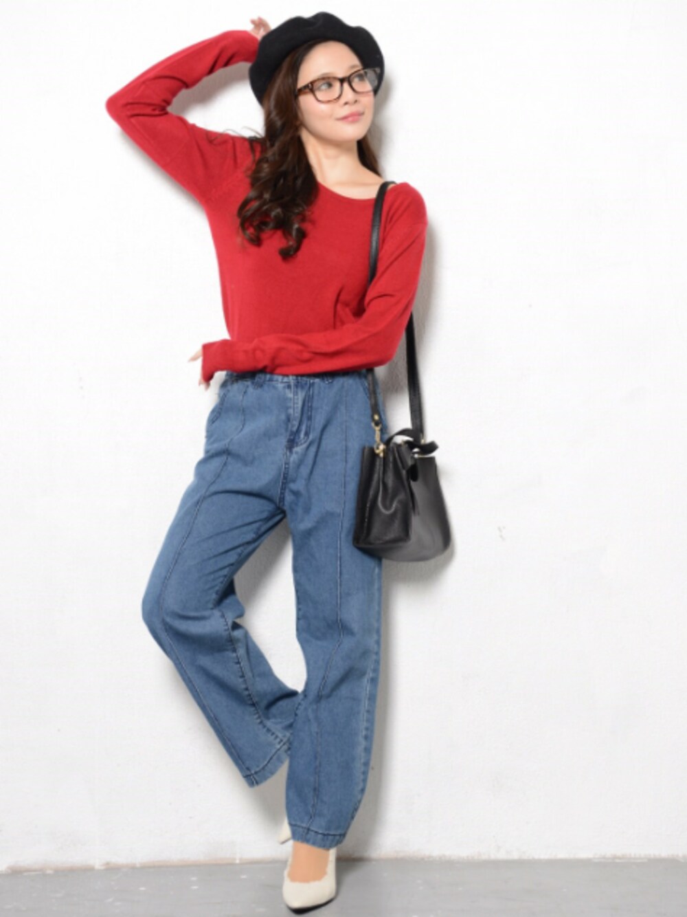 レッド系のトップス、ブラック系のバッグ、ブルー系のパンツを着用したレディースの冬コーディネートの1枚目の写真