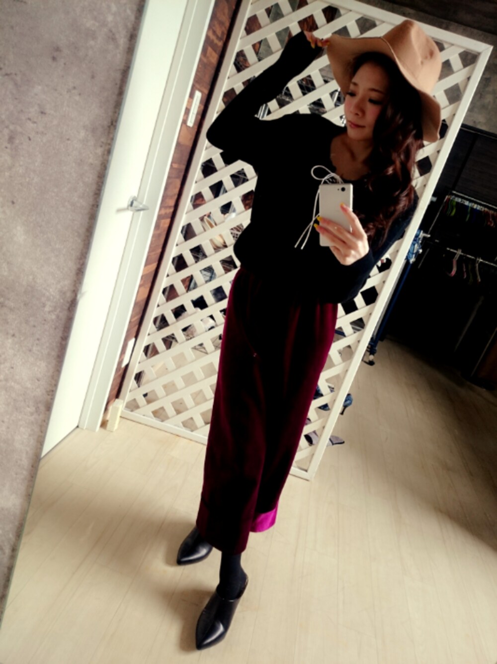 レッド系のパンツ、ブラック系のシューズ、ブラック系のトップスを着用したレディースの春コーディネートの1枚目の写真