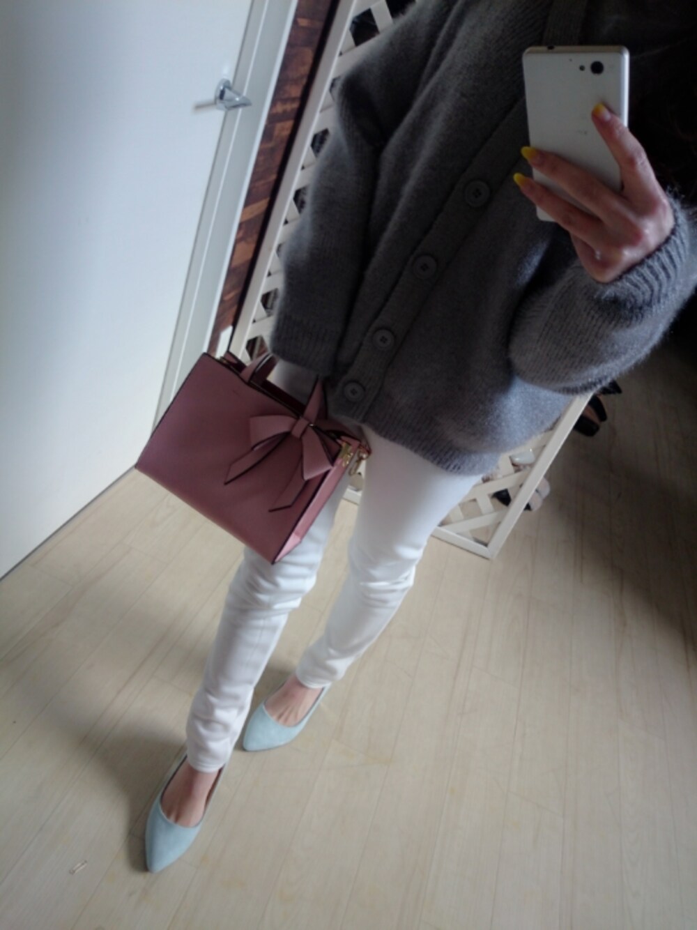 グレー系のトップス、ピンク系のバッグ、ブルー系のシューズを着用したレディースの春コーディネートの1枚目の写真