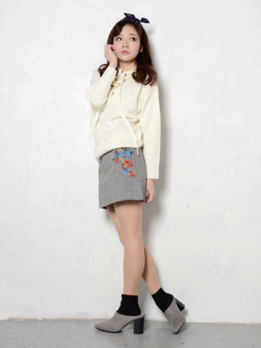 ホワイト系のトップス、グレー系のスカート、グレー系のシューズを着用したレディースの春コーディネートの1枚目の写真