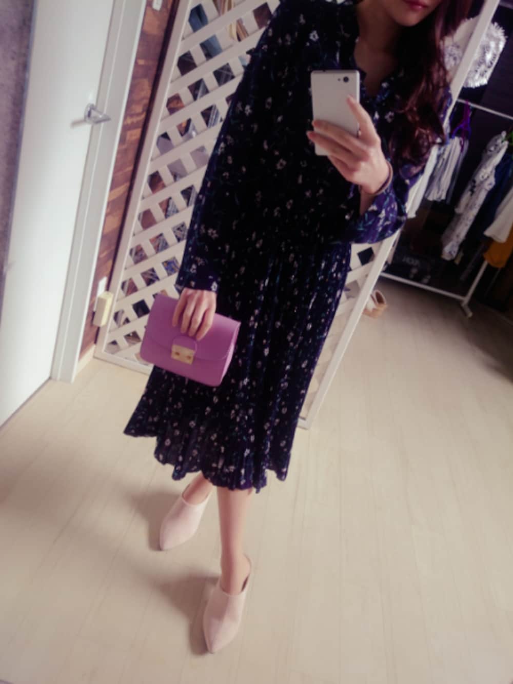 ブラック系のワンピース、ピンク系のクラッチバッグ、ピンク系のシューズを着用したレディースの春コーディネートの1枚目の写真