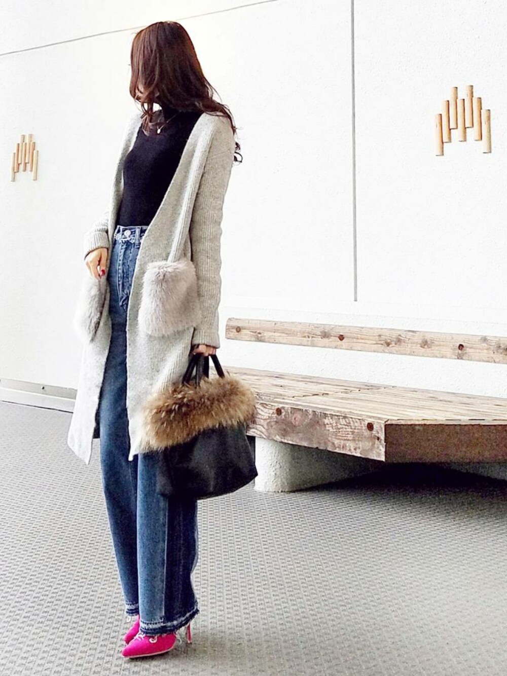 ブラック系のニット/セーター、グレー系のカーディガン/ボレロ、ブルー系のデニムパンツを着用したレディースの冬コーディネートの1枚目の写真