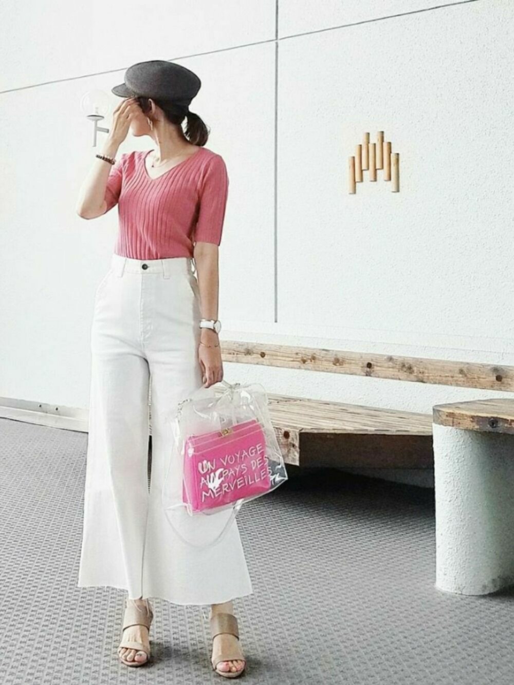 ピンク系のニット/セーター、ピンク系のハンドバッグ、ホワイト系のデニムパンツを着用したレディースの夏コーディネートの1枚目の写真
