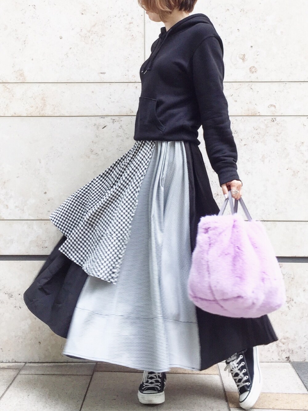 ブラック系のパーカー、パープル系のショルダーバッグ、ブラック系のスカートを着用したレディースの春コーディネートの1枚目の写真