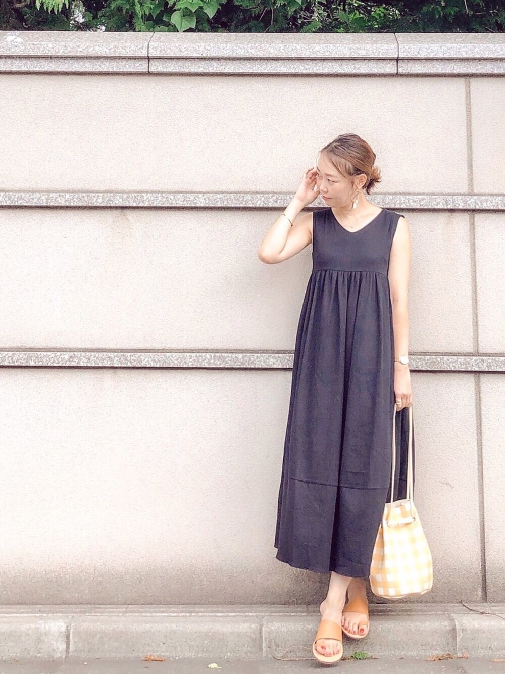 ブラック系のワンピース、ブラウン系のサンダル、イエロー系のショルダーバッグを着用したレディースの夏コーディネートの1枚目の写真