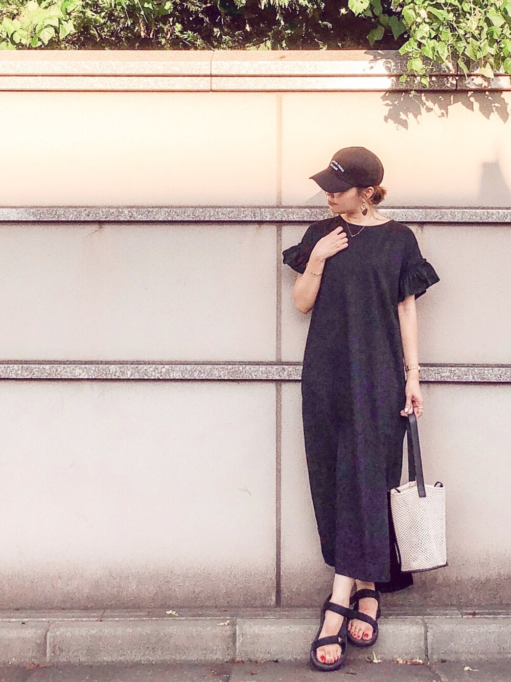 ブラック系のワンピース、ブラック系のトートバッグ、ブラック系のサンダルを着用したレディースの夏コーディネートの1枚目の写真