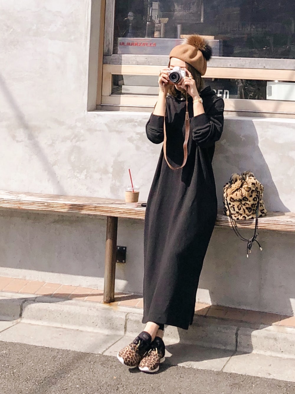 ブラック系のワンピース、ブラウン系のショルダーバッグ、ベージュ系のスニーカーを着用したレディースの秋コーディネートの1枚目の写真