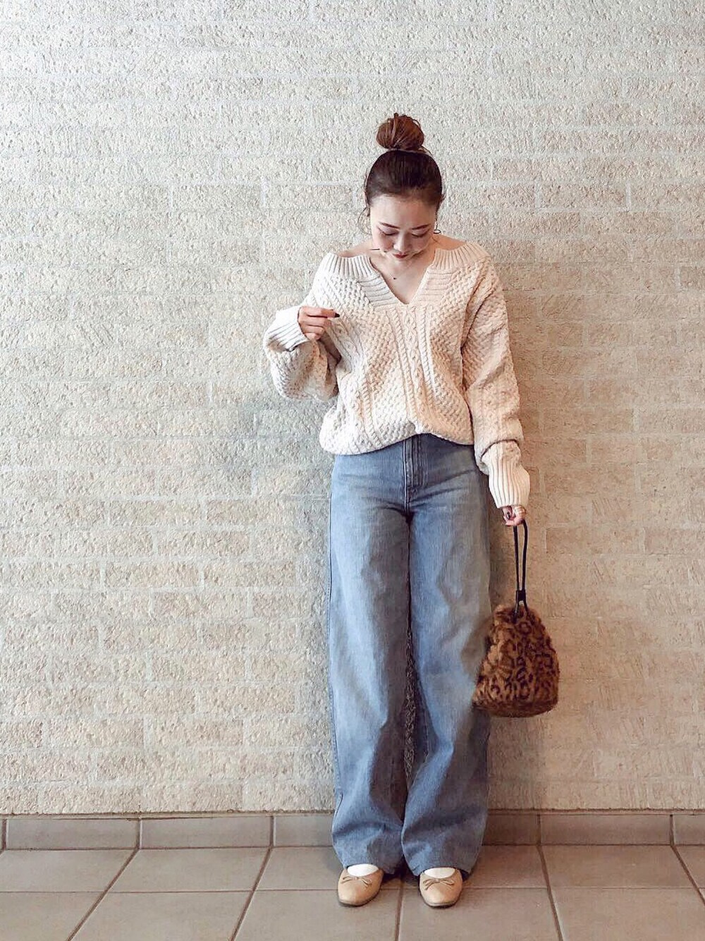 ベージュ系のニット/セーター、ブルー系のデニムパンツ、ベージュ系のバレエシューズを着用したレディースの冬コーディネートの1枚目の写真