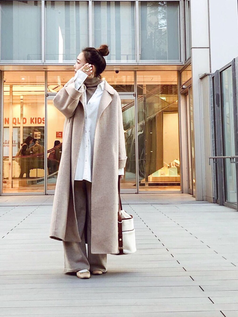 ホワイト系のシャツ/ブラウス、ベージュ系のステンカラーコート、ブラウン系のハンドバッグを着用したレディースの冬コーディネートの1枚目の写真