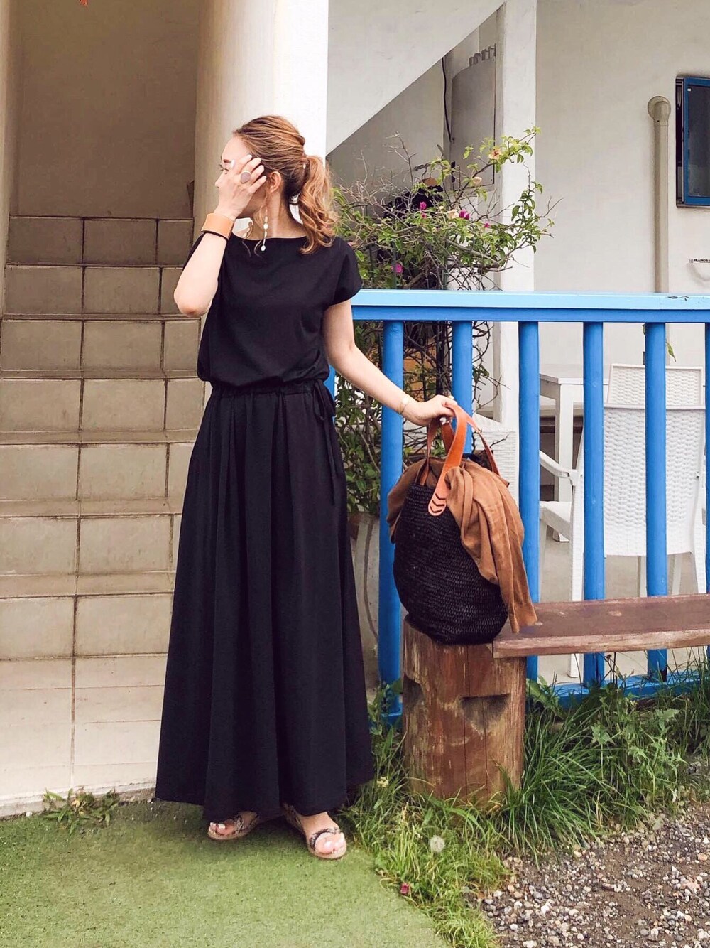 ブラック系のワンピース、その他のサンダル、ブラウン系のバングル/リストバンドを着用したレディースの夏コーディネートの1枚目の写真