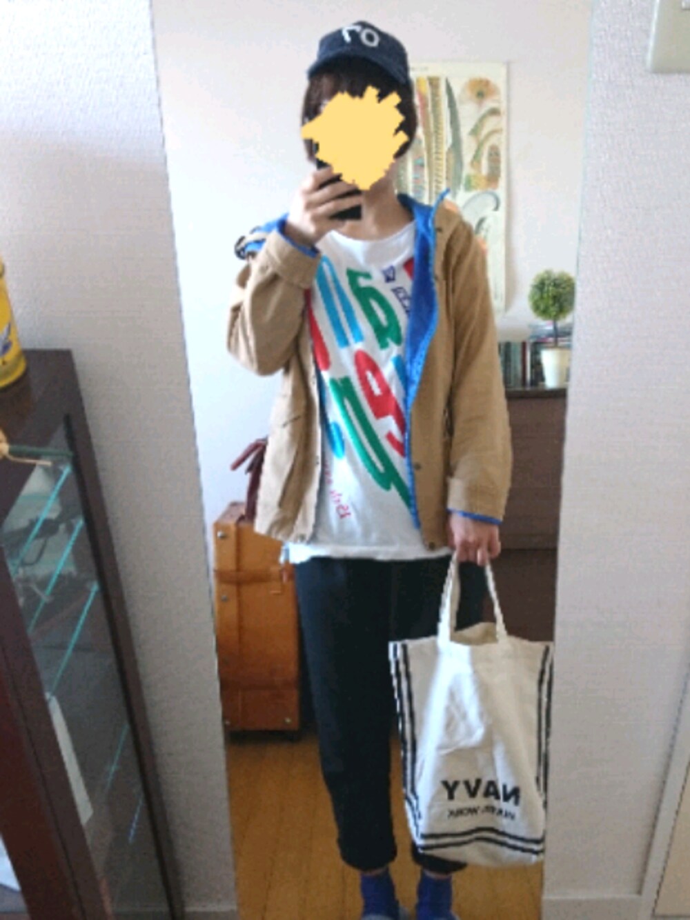 ベージュ系のマウンテンパーカー、ブルー系のキャップを着用したレディースの冬コーディネートの1枚目の写真