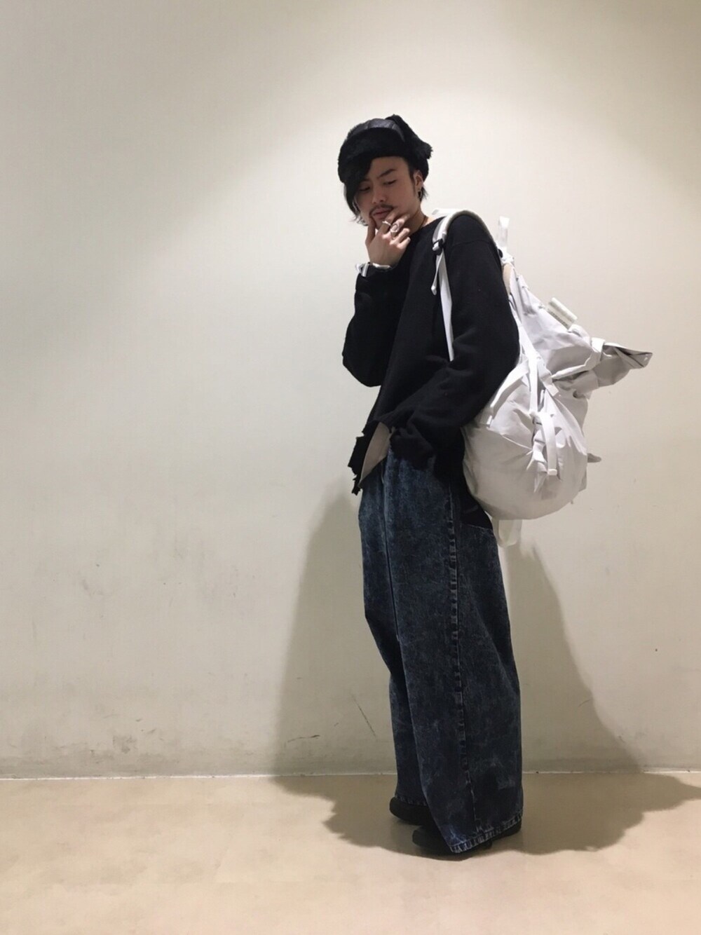 グレー系のTシャツ/カットソー、ブラック系のニット/セーター、ブルー系のデニムパンツを着用したメンズの冬コーディネートの1枚目の写真