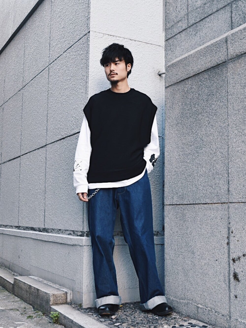 ブラック系のベスト、ブルー系のデニムパンツ、シルバー系のウォレットチェーンを着用したメンズの春コーディネートの1枚目の写真