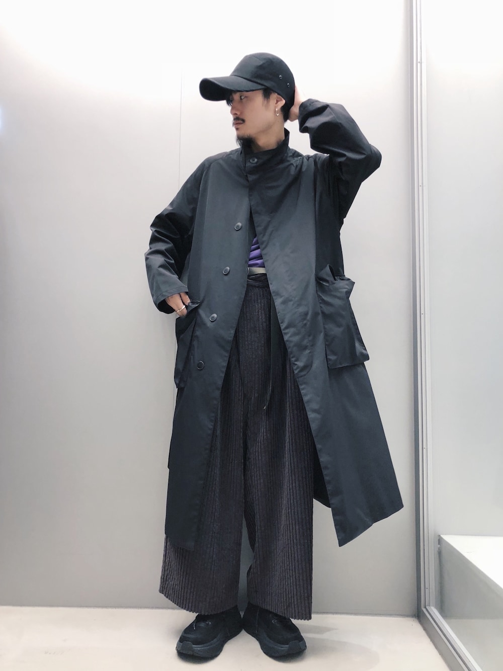 ブラック系のトレンチコート、グレー系のその他パンツ、ブラック系のスニーカーを着用したメンズの秋コーディネートの1枚目の写真