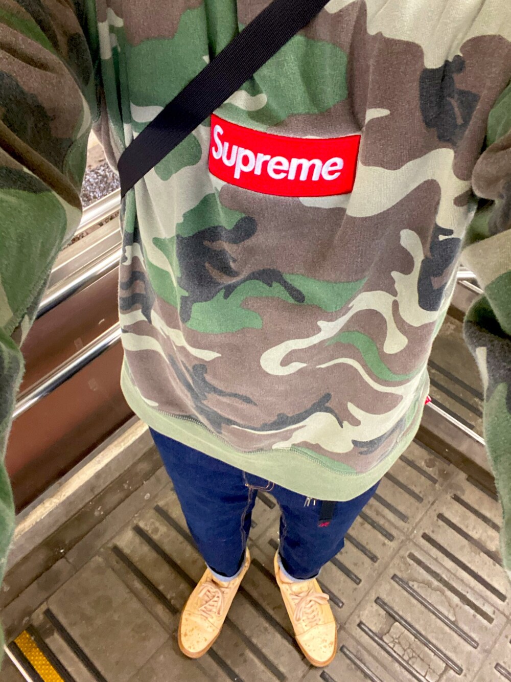 グリーン系のスウェット、ブルー系のデニムパンツ、ベージュ系のスニーカーを着用したメンズの春コーディネートの1枚目の写真