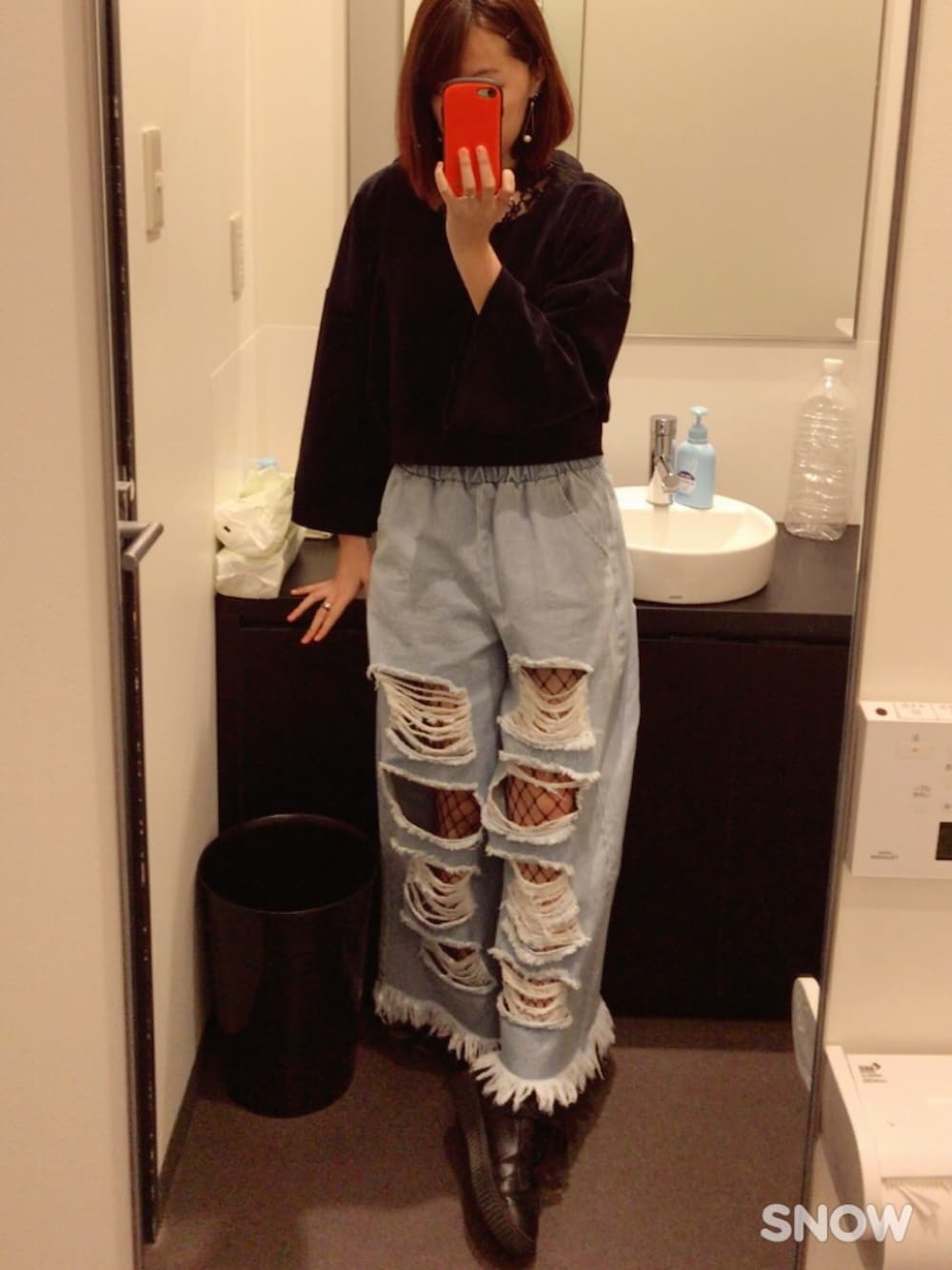 ブルー系のデニムパンツ、ブラック系のスウェット、その他のスニーカーを着用したレディースの冬コーディネートの1枚目の写真