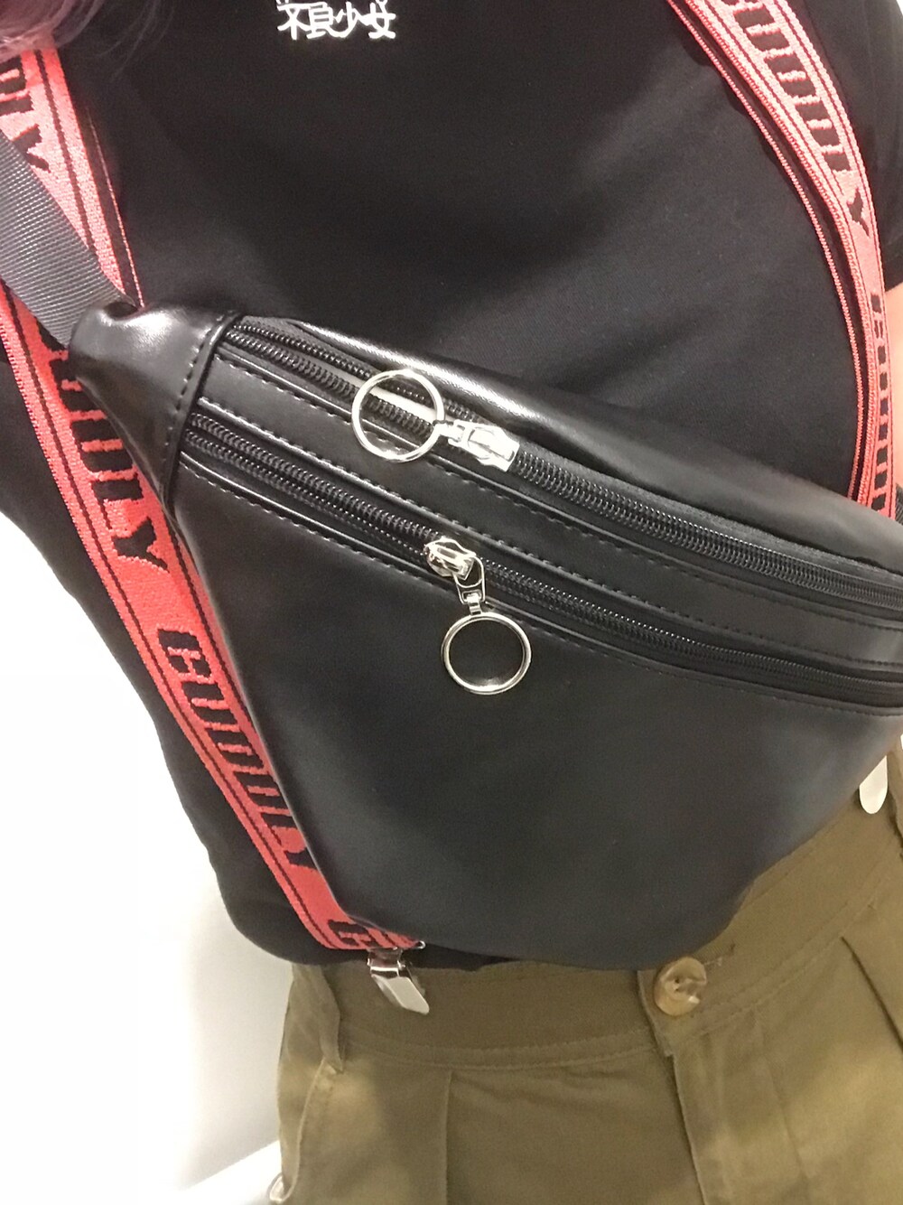 グリーン系のスカート、ブラック系のTシャツ/カットソー、レッド系のサスペンダーを着用したレディースの夏コーディネートの1枚目の写真