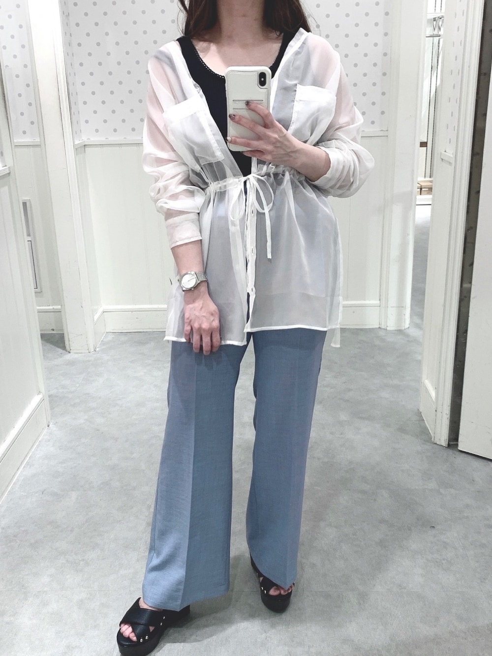 ブラック系のタンクトップ、ホワイト系のシャツ/ブラウス、ブルー系のスラックスを着用したレディースの春コーディネートの1枚目の写真