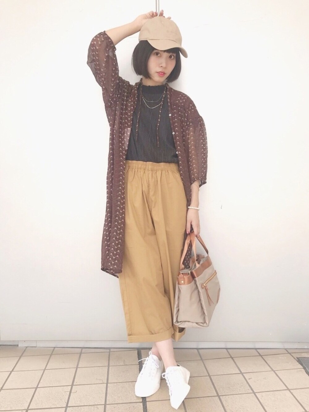 ベージュ系のトートバッグ、ホワイト系のスニーカー、ブラウン系のワンピースを着用したレディースの夏コーディネートの1枚目の写真