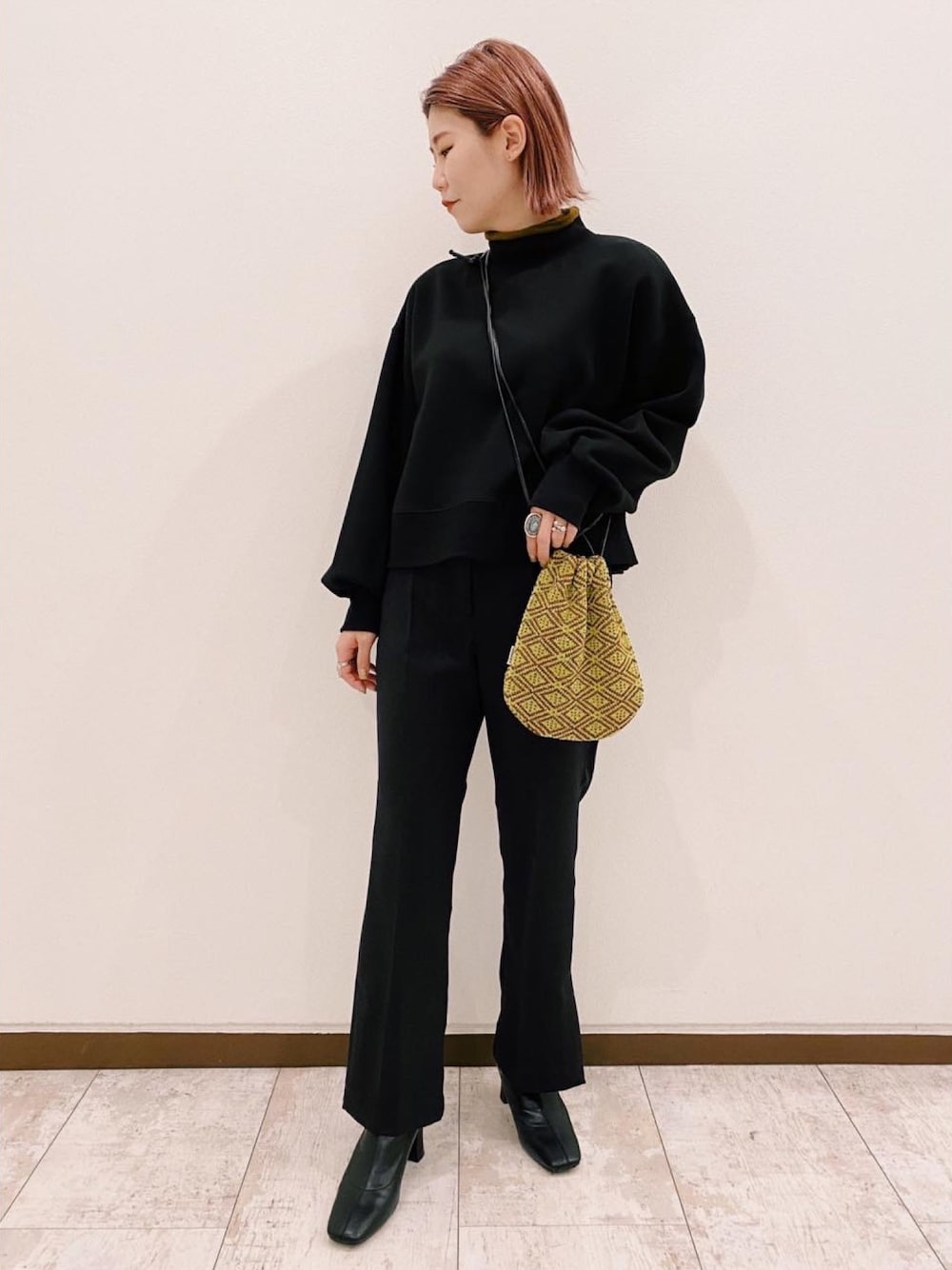 ブラック系のスウェット、グリーン系のショルダーバッグ、ブラック系のその他パンツを着用したレディースの冬コーディネートの1枚目の写真