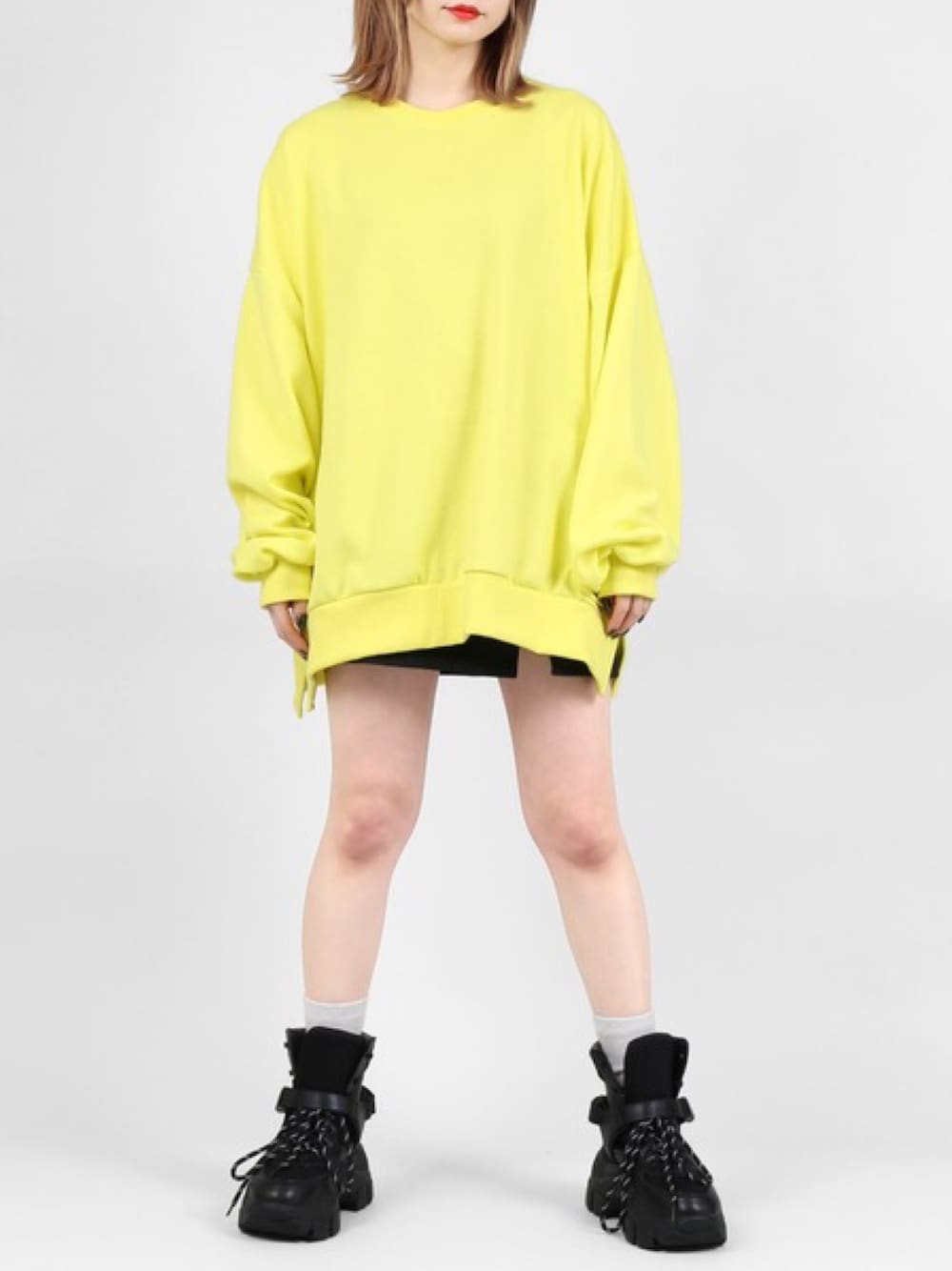 イエロー系のスウェット、ブラック系のスカートを着用したレディースの春コーディネートの1枚目の写真