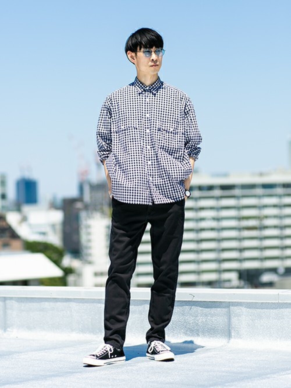 ブラック系のチノパンツ、シルバー系のサングラスを着用したメンズの春コーディネートの1枚目の写真