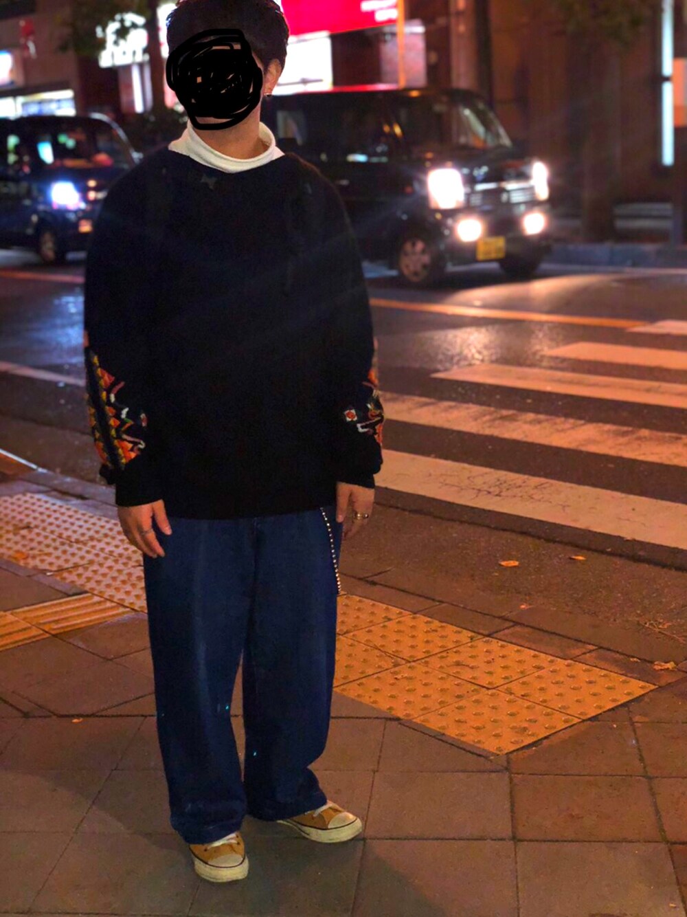 ブラック系のニット/セーター、ブルー系のデニムパンツ、イエロー系のスニーカーを着用したメンズの秋コーディネートの1枚目の写真