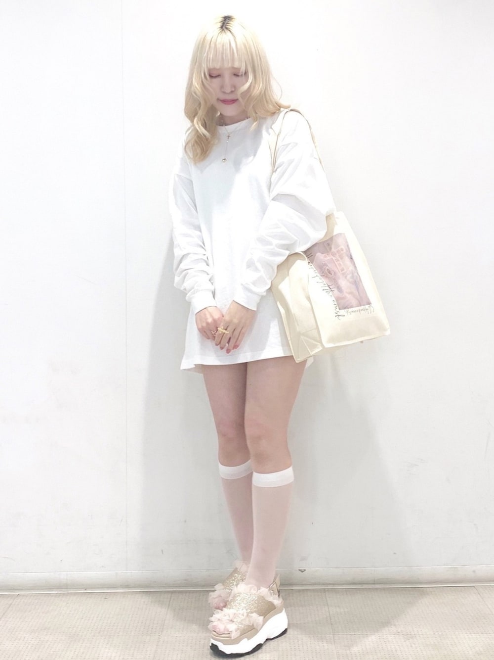 ピンク系のトートバッグ、ベージュ系のサンダル、パープル系のTシャツ/カットソーを着用したレディースの春コーディネートの1枚目の写真