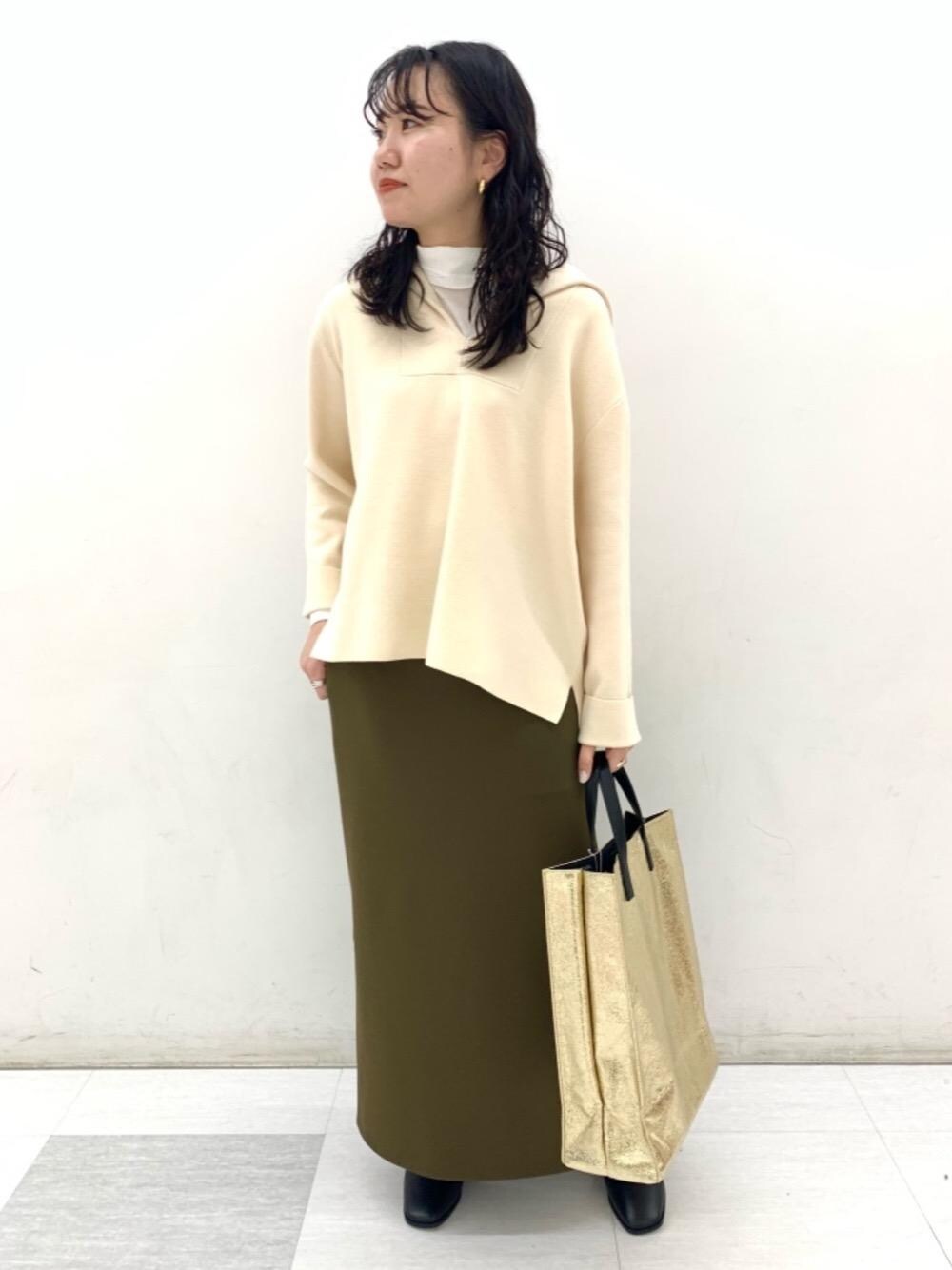 ホワイト系のTシャツ/カットソー、ゴールド系のトートバッグ、ブラック系のブーツを着用したレディースの秋コーディネートの1枚目の写真