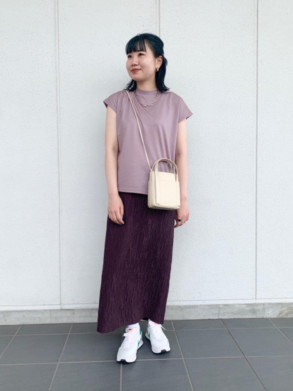 ベージュ系のショルダーバッグ、パープル系のTシャツ/カットソー、ブラウン系のスカートを着用したレディースの夏コーディネートの1枚目の写真