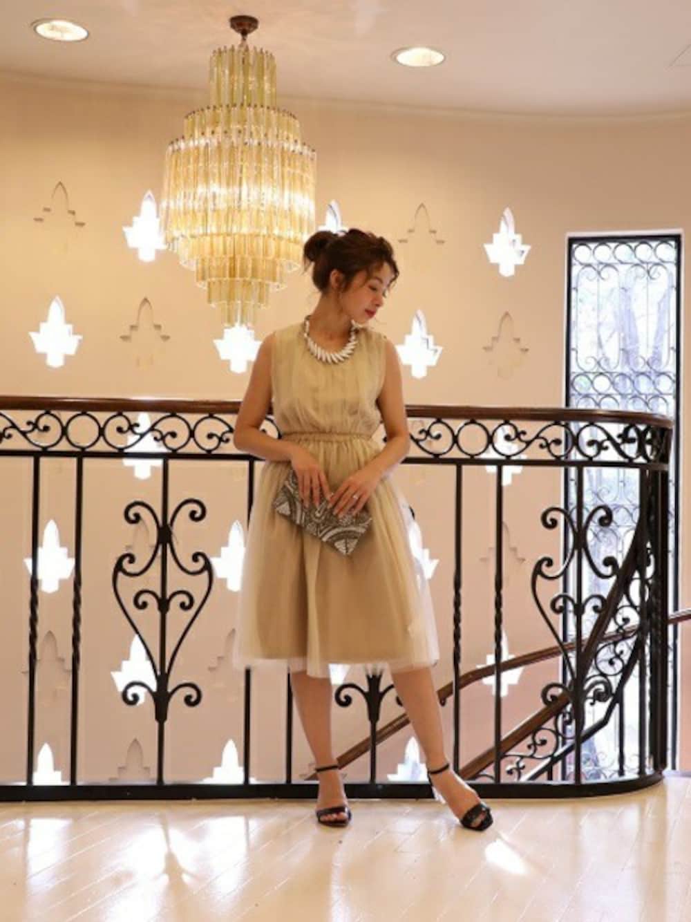 ベージュ系のワンピース、グレー系のクラッチバッグ、ブラック系のサンダルを着用したレディースの春コーディネートの1枚目の写真