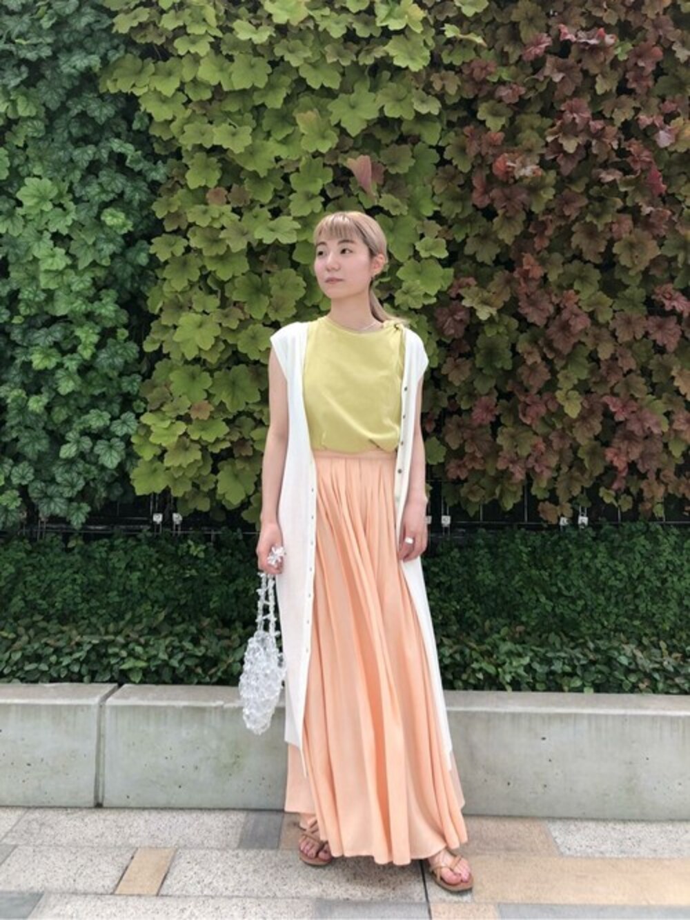 ピンク系のスカート、イエロー系のスウェット、ホワイト系のワンピースを着用したレディースの夏コーディネートの1枚目の写真