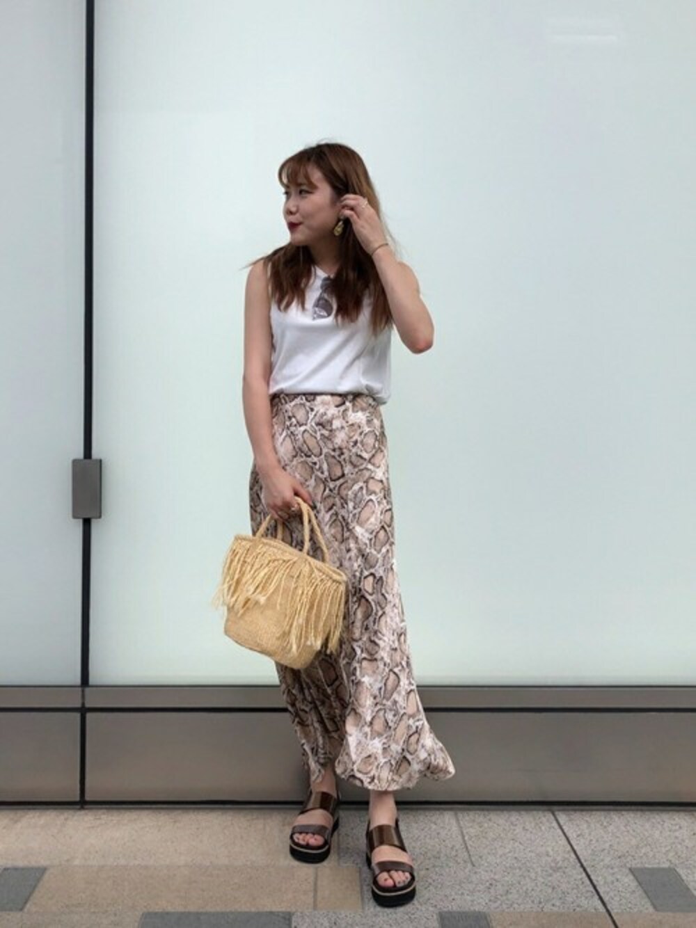 ホワイト系のスウェット、ベージュ系のスカート、ゴールド系のサンダルを着用したレディースの夏コーディネートの1枚目の写真