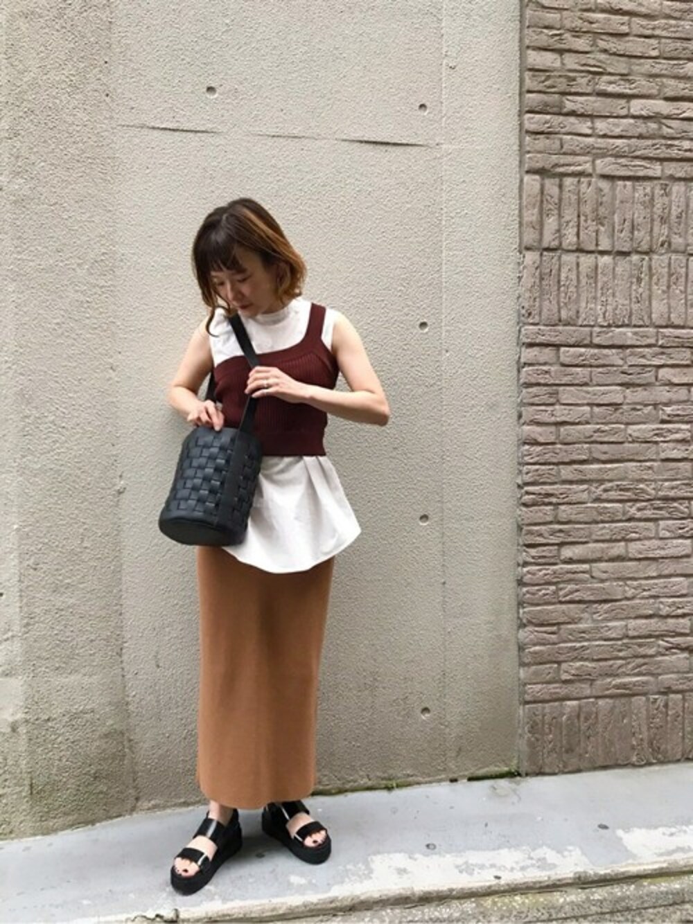 ベージュ系のスカート、ブラウン系のシャツ/ブラウス、ブラック系のサンダルを着用したレディースの夏コーディネートの1枚目の写真