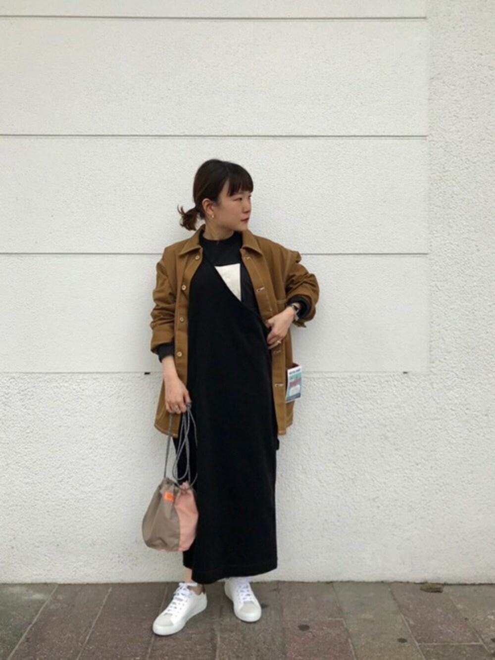 ブラック系のジャンパースカート、ブラック系のTシャツ/カットソー、ベージュ系のショルダーバッグを着用したレディースの夏コーディネートの1枚目の写真