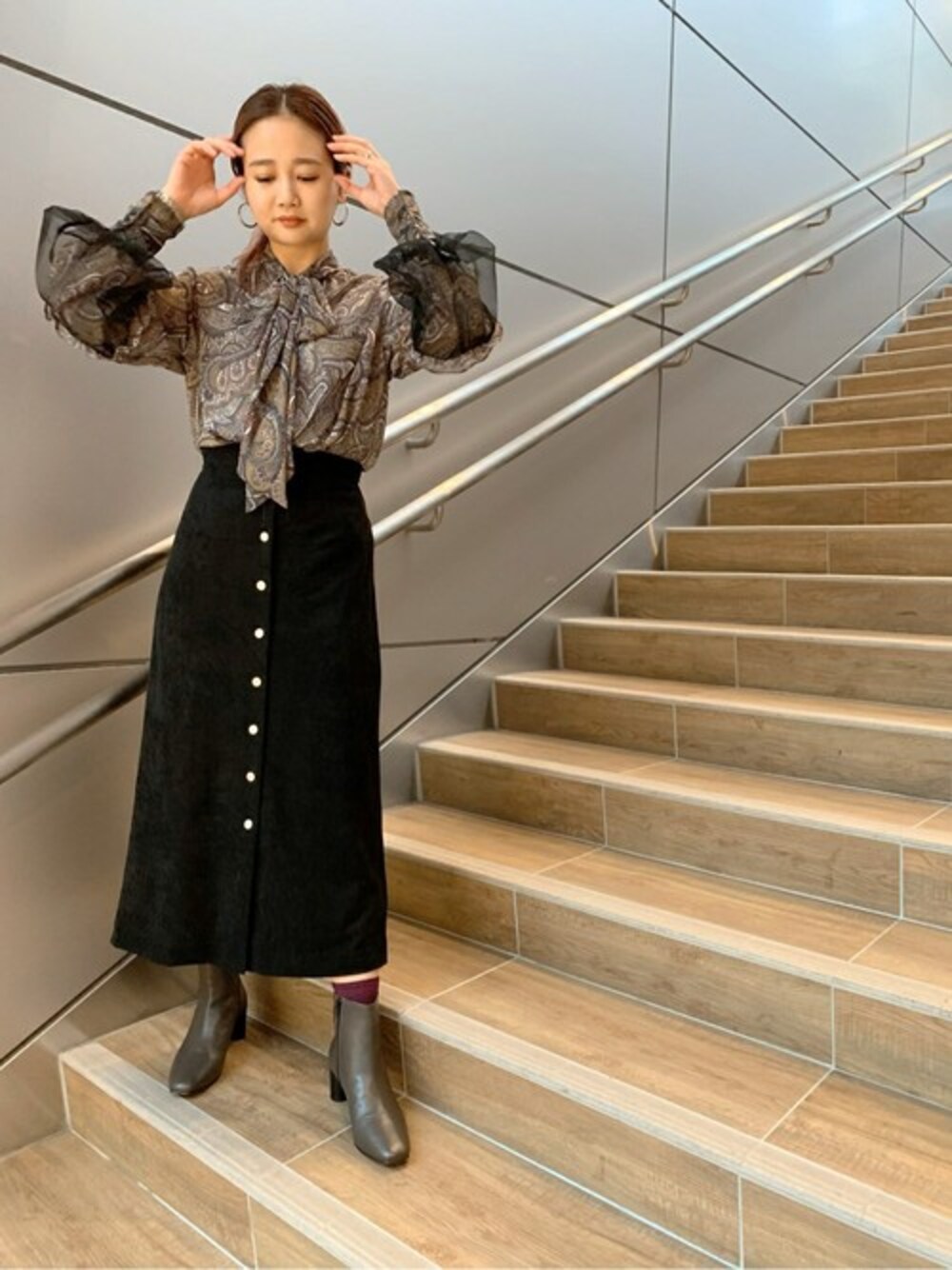 ベージュ系のシャツ/ブラウス、ブラック系のスカート、グレー系のブーツを着用したレディースの秋コーディネートの1枚目の写真