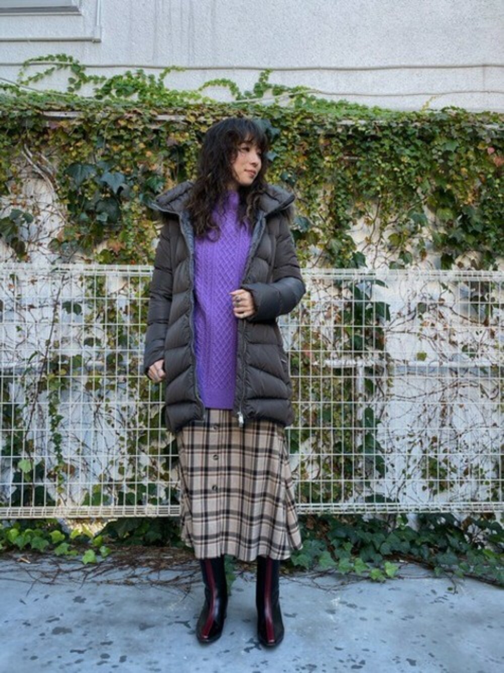 パープル系のニット/セーター、ベージュ系のワンピース、グレー系のダウンジャケット/コートを着用したレディースの冬コーディネートの1枚目の写真